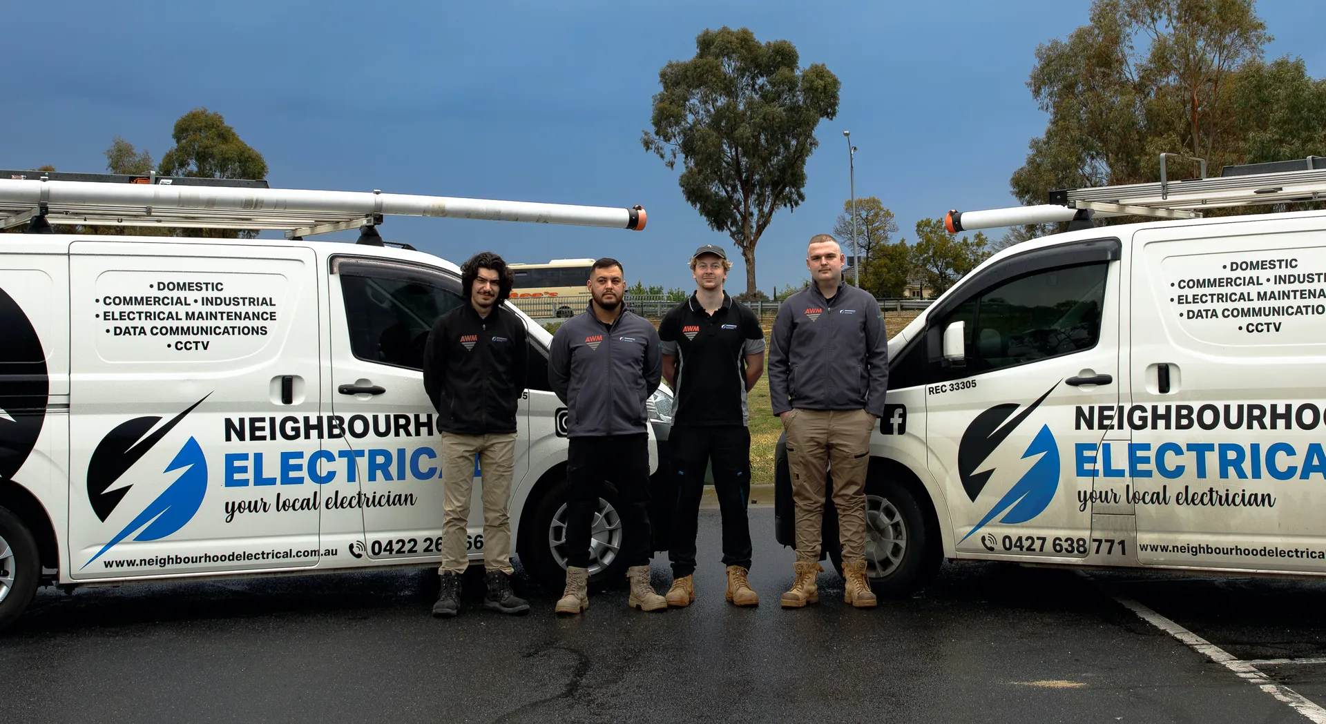 Team of electricians with service vehicles outdoors.